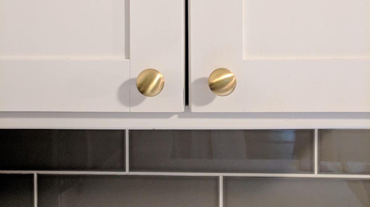gold cabinet knobs on a white cabinet