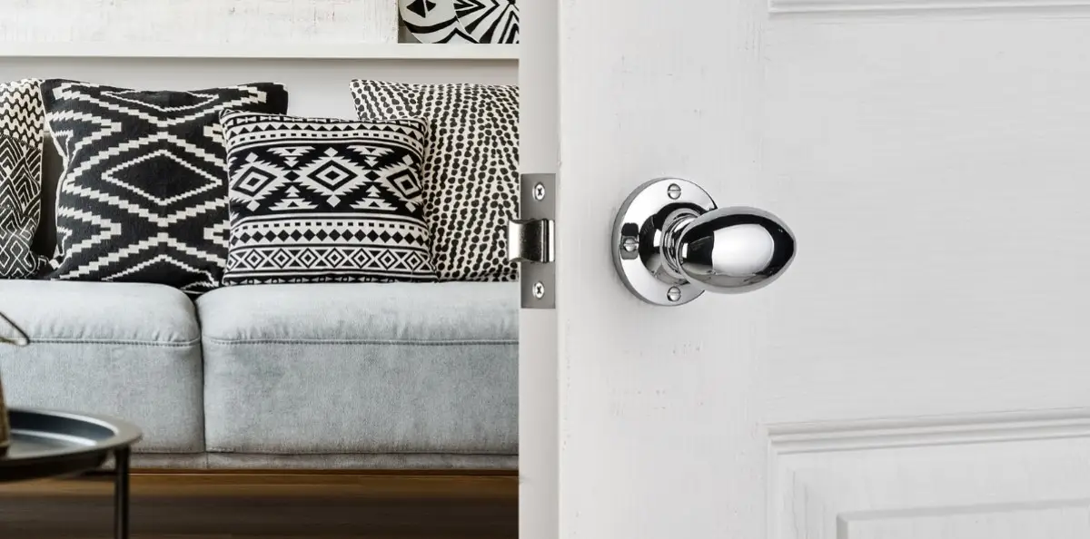 silver oval door knob on a white wooden door